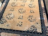 un tapis oriental posé à même le sol dans une pièce où se trouvent une chaise et une table