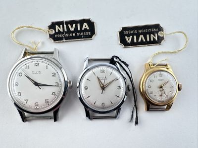 trois montres sont assises l'une à côté de l'autre sur une surface blanche