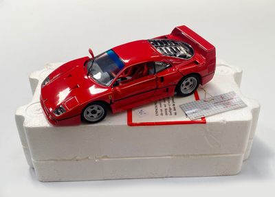 une petite voiture rouge posée sur une boîte blanche