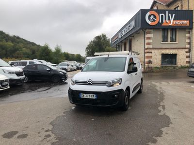 La camionnette blanche est garée devant un immeuble dans la rue.