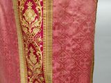 a close up of a red and gold cloth with a cross on it