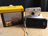 a small camera sitting next to a box on a table