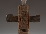 a close up of a wooden cross on a stand on a white surface