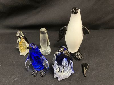 trois pingouins en verre assis les uns à côté des autres sur une table