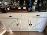 a white cabinet with a lot of bottles on it