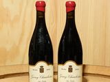 deux bouteilles de vin posées sur un tonneau