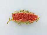 une photo d'une broche ornée de trois roses