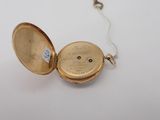 an image of a gold pocket watch with a chain on a white surface