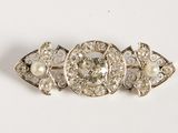 an image of a close up of a brooch with pearls on it