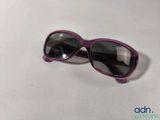 purple sunglasses laying on a white surface with a white background