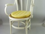 a white chair with a yellow seat pad on it