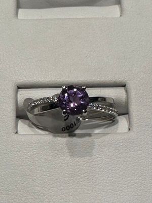 une photo d'une bague en diamant violette dans un écrin blanc