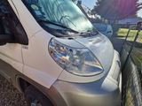 a white van parked in a parking lot next to a fence