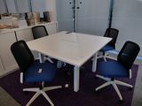une table blanche avec des chaises bleues dans une pièce