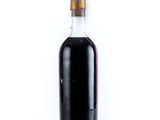 a bottle of syrup sitting on a white surface