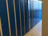 de nombreux casiers bleus dans le couloir d'un immeuble