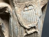an ancient statue of a man with a beard on a wooden stand