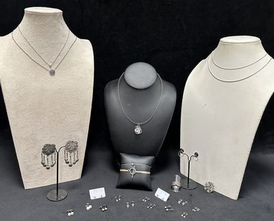 three mannequins with necklaces and earrings on display on a black background
