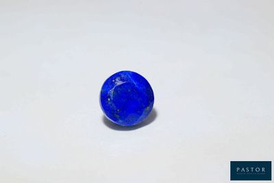 gros plan d'une pierre bleue sur une surface blanche