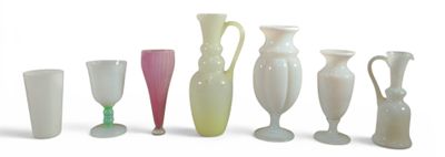 several different colored vases are lined up on a white surface