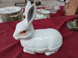 une figurine de lapin blanc posée sur une nappe rouge