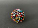 a multicolored beaded ring on a black surface
