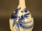 a blue and white vase with a bird on it