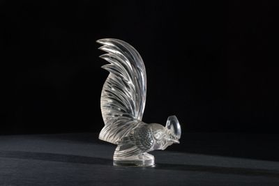a glass figurine of a rooster on a black surface
