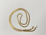 a close up of a gold chain on a white surface