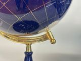 a blue and gold globe sitting on a blue stand