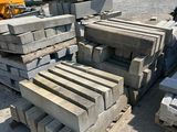 a pile of concrete blocks on the ground next to a bulldozer