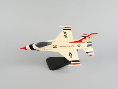 une petite maquette d'avion de chasse posée sur un socle