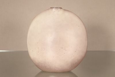 un vase blanc posé sur une table en verre