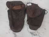 une paire de bottes en cuir marron posées sur un sol en marbre, avec une étiquette sur la semelle