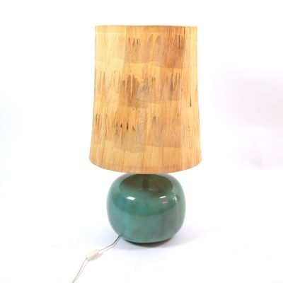 a green lamp with a wooden shade on top of it