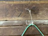 a green rope hanging from the side of a wooden box