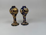 pair of blue and gold vases sitting on a white surface
