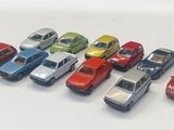 several toy cars are lined up in a row on a white surface