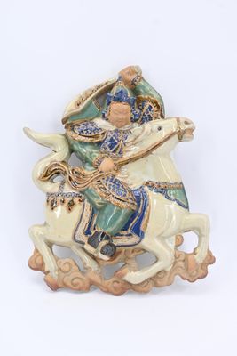 une figurine représentant un homme à cheval sur fond blanc