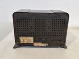 an old black radio sitting on top of a white table