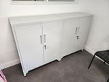 a white cabinet in the corner of a room with a mirror