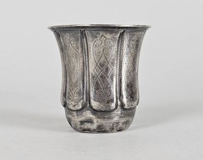 an antique silver vase sitting on top of a white table