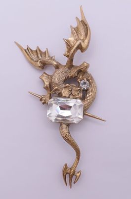 a close up of a brooch with a dragon on it