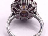 a close up of a silver ring with a red stone in it