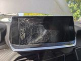 a broken cell phone sitting on the dashboard of a car
