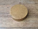 a brown box sitting on a wooden table with a black wall in the background