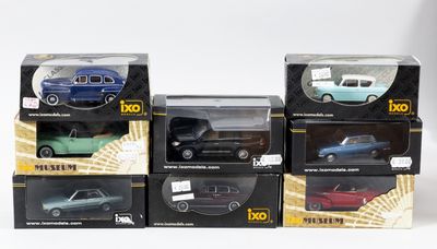 six modèles différents de voitures dans des boîtes, posées sur une surface blanche