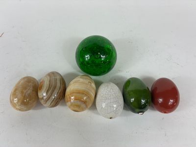 Plusieurs billes de différentes couleurs sont alignées sur une surface blanche.