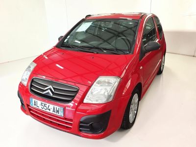 a red car that is parked in a white room