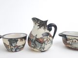 three pieces of pottery that are sitting on a table